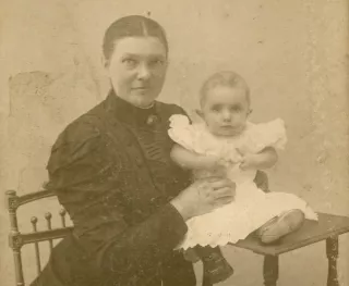 Oude vergeelde foto van vrouw en baby